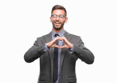 Genç yakışıklı iş adamı aşık kalp simgesi ve elleriyle şekil gösteren gülümseyen izole arka plan üzerinde. Romantik kavramı.