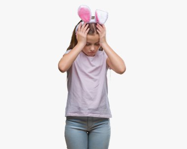 Paskalya bunny kulaklar çünkü umutsuz ve stresli baş ağrısı acı izole arka plan üzerinde giyen genç güzel kız acı ve migren. Ellerini kafasına.