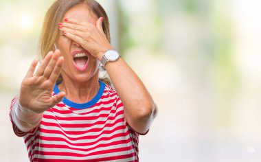 Orta yaş üst düzey İspanyol kadın izole elleriyle gözlerini kapsayan arka plan ve stop jest ile acı ve korku ifadesi. Utandım ve negatif kavramı.