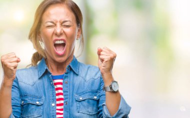 Orta yaş üst düzey İspanyol kadın yüzünden kızgın ve silah ile başarı için deli kutluyor izole arka plan ortaya çıkar ve heyecanlı çığlık gözler kapalı. Kazanan kavramı