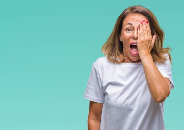 Orta yaş bir göz ile yüz ve sürpriz duygu kendinden emin gülümseme ile el kapsayan izole arka plan üzerine İspanyol kadın kıdemli.