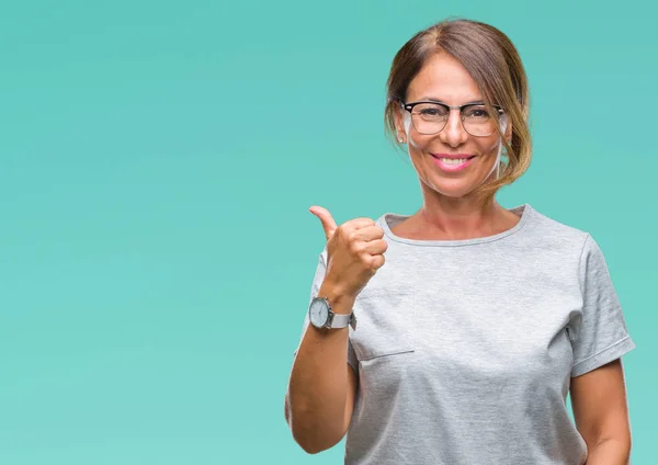 中年资深西班牙裔妇女戴眼镜在孤立的背景下做高兴的拇指手势与手 批准表达式看相机与显示成功 — 图库照片