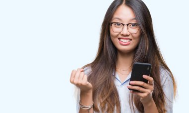 Genç Asyalı kadın manifatura Smartphone gurur çığlık ve zafer ve başarı çok heyecanlı, duygu tezahürat kutluyor izole arka plan üzerinde kullanma