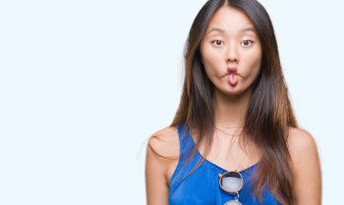 Genç Asyalı kadın izole arka plan yapma balık yüzüne dudaklı, çılgın ve komik bir jest. Komik ifade.