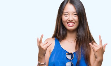 Genç Asyalı kadın deli ifade rock simge elle yapıyor ile bağırarak izole arka plan üzerinde. Müzik yıldızı. Ağır kavramı.