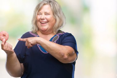 Üst düzey artı boyutu kafkas kadın izole arka el ve parmak ile işaret çok mutlu üzerinde şeker donut yemek