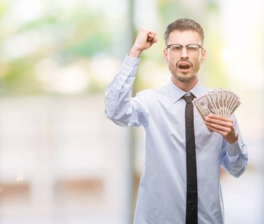 Dolar tutan genç yenilikçi iş adamı rahatsız ve boşa çıkarmak ile öfke, çılgın da yükseltilmiş el ile bağırmaya kavramı öfke