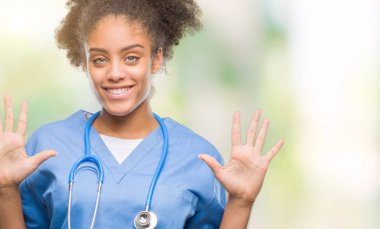 Genç afro Amerikalı doktor kadın gösterilen ve parmakları ile işaret izole arka plan yüzünden kendinden emin ve mutlu gülümseyerek süre on numara.