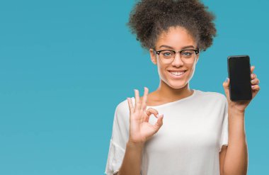 Genç güzel afro Amerikan gösteren smartphone ekran parmak, mükemmel sembolü ile ok işareti yapıyor izole arka plan üzerinde