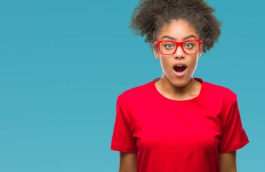Korkuyor ve şok sürpriz ifade, korku ve heyecan yüz ile izole arka plan üzerinde gözlük takan genç afro Amerikalı kadın.