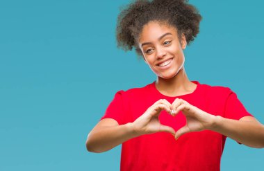 Genç afro Amerikan kadın kalp simgesi ve elleriyle şekil gösterilen aşık gülümseyen izole arka plan yüzünden. Romantik kavramı.
