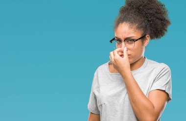 Gözlük takan bir şey pis ve iğrenç kokulu izole arka plan, dayanılmaz koku, holding nefes burun parmaklar ile genç afro Amerikalı kadın. Kötü kokuyor kavramı.