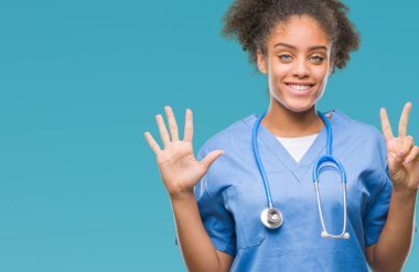 Genç afro Amerikalı doktor kadın gösterilen ve parmakları ile işaret izole arka plan yüzünden kendinden emin ve mutlu gülümseyerek süre yedi numara.