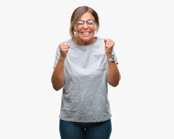 中世纪资深西班牙裔妇女戴着眼镜 在孤立的背景下兴奋地举起双臂庆祝胜利的微笑 赢家理念 — 图库照片