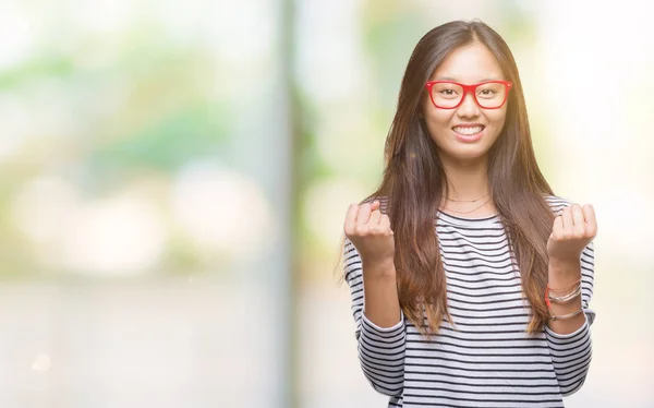 眼鏡をかけて孤立した背景を祝う上若いアジア女性は驚きし びっくりの腕の成功のため調達と開いた目 勝者の概念 — ストック写真