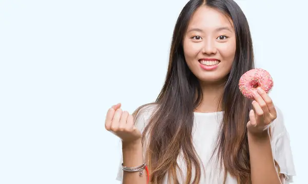 Jovem Asiático Mulher Comer Donut Sobre Isolado Fundo Gritando Orgulhoso — Fotografia de Stock