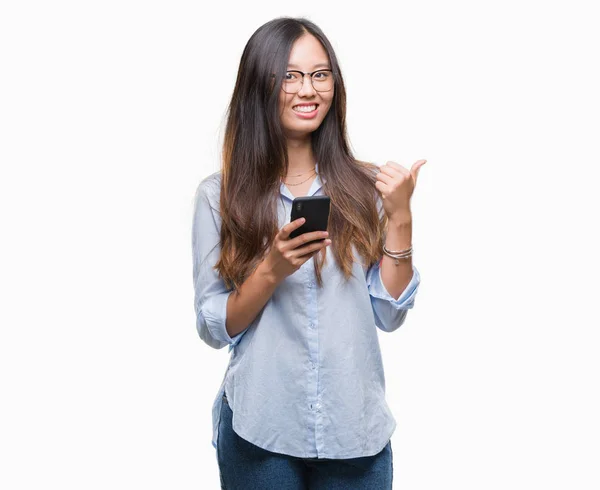 指していると幸せそうな顔を笑顔で側まで親指で示す分離の背景にスマート フォンを使用して若いアジア女性のテキスト メッセージ — ストック写真