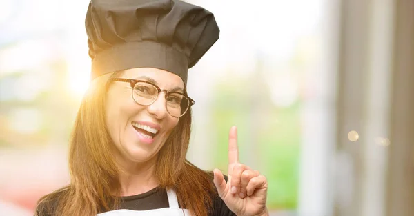 Köchin Mittleren Alters Trägt Kochschürze Und Zeigt Mit Finger Zur — Stockfoto