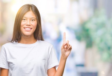 Genç Asyalı kadın ve kendinden emin ve mutlu gülümseyerek süre parmak numaralı yukarıyı gösteren izole arka plan üzerinde.