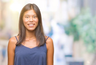 Genç Asyalı kadın yüzünde mutlu ve güzel bir gülümseme ile izole arka plan üzerinde. Şanslı kişi.