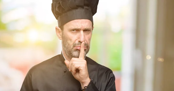 高级厨师 戴着食指在嘴唇上的主厨帽 要求安静 沉默和秘密概念 — 图库照片