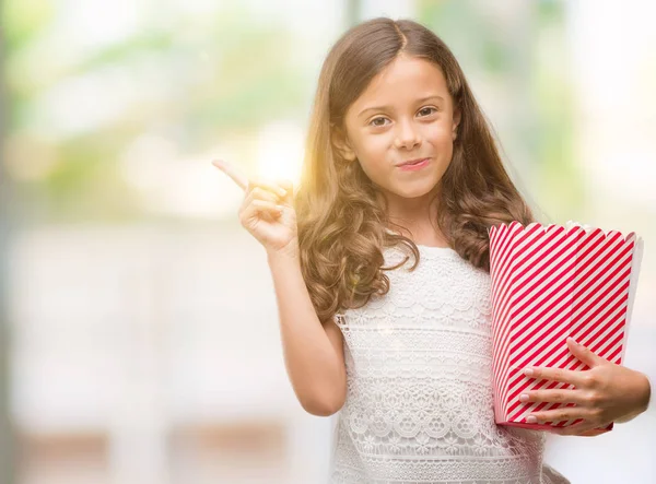 Brunette Hispanic Girl Eating Popcorn Very Happy Pointing Hand Finger — Stock Photo, Image