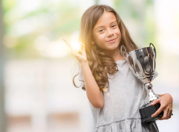 Brunette Hispanic Girl Holding Trophy Very Happy Pointing Hand Finger — Stock Photo, Image