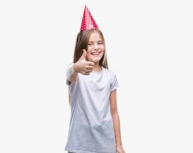 Genç güzel kız mutlu yaşasın el ile jest yapıyor izole arka plan üzerinde Doğum günü şapkası. Kameraya bakarak başarı gösteren ile ifade onaylama.