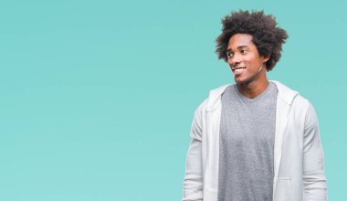 Afro Amerikalı adam uzak tarafına yüzünde, doğal ifade gülümseme ile seyir izole arka plan üzerinde kazak giyiyor. Kendine güvenen gülüyor.