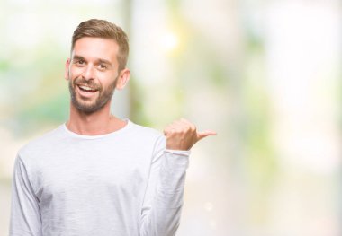 Yakışıklı delikanlı arıyor ve başparmak yanında yukarıyı mutlu yüz ile gülümseyen izole arka plan üzerinde.