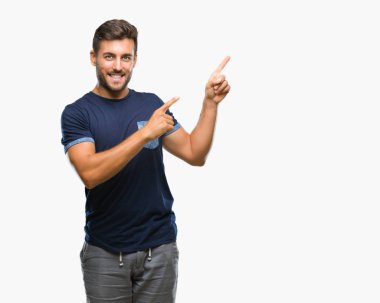 Yakışıklı delikanlı gülümseyen ve iki elleri ve parmakları ile tarafına işaret kamera bakarak izole arka plan üzerinde.