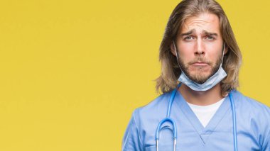 Sarı arka plan üzerinde uzun saçlı Genç yakışıklı erkek doktor