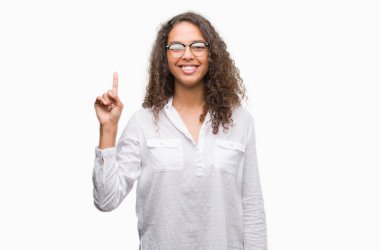 Gösterilen ve parmak numara ile yukarı dönük kendinden emin ve mutlu gülümseyen güzel genç İspanyol kadın.