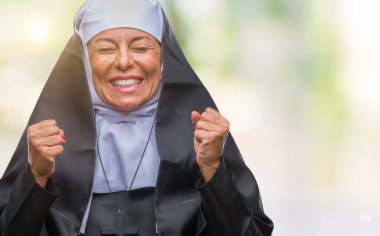 Orta yaş üst düzey Hıristiyan Katolik Rahibe kadın izole arka kolları olan başarı için heyecan üzerinde zafer kutluyor gülümseyen kaldırdı. Kazanan kavramı.