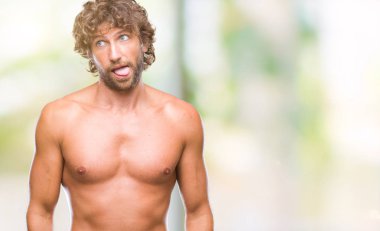 Yakışıklı İspanyol modeli adam seksi ve gömleksiz dilini izole arka plan üzerinde out komik ifade ile mutlu. Duygu kavramı.