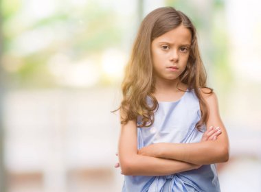 Esmer Latin kız şüpheci ve sinir, onaylamayan ifade yüz çapraz kolları üzerinde. Negatif kişi.