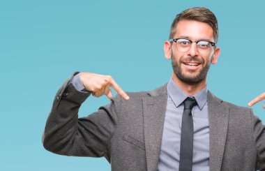Genç yakışıklı iş adamı yüzünde gülümseme ile kendinden emin görünüyorsun, kendini gururlu ve mutlu parmakları ile işaret izole arka plan üzerinde.