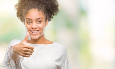 Genç afro Amerikan kadın hareketi el ile mutlu yaşasın yapıyor izole arka plan yüzünden. Kameraya bakarak başarı gösteren ile ifade onaylama.