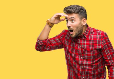 Yakışıklı delikanlı izole arka plan çok mutlu ve gülümseyen uzakta el ile üzerine kafa seyir üzerinde. Arama kavramı.