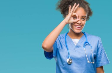 Genç afro Amerikalı doktor kadın gülümsüyor, parmakları ile mutlu yüz üzerinden seyir göz el ile ok jest yapıyor izole arka plan.