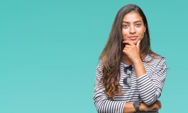 Genç güzel Arap kadın emin çapraz kollar ve çeneme kaldırdı el ile gülümseme ile kameraya bakarak izole arka plan üzerinde güneş gözlüğü takıyor. Pozitif düşünce.