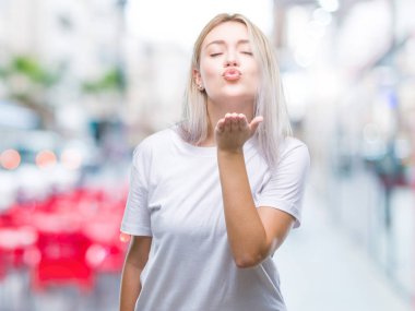 Sarışın genç kadın bir öpücük el ile güzel ve seksi olmak hava üfleme kamera bakarak izole arka plan üzerinde. Aşk ifade.