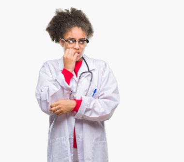 Genç afro Amerikalı doktor kadın yüzünden stresli ve gergin elle çivi ısırma ağzına bakarak izole arka plan. Anksiyete sorunu.
