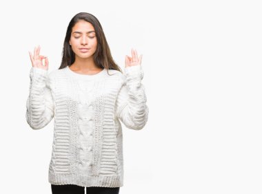 Genç güzel Arap kadın giyiyor kış kazak izole arka plan üzerinde dinlenmek ve gülümseyen gözlerle kapalı parmak jestle meditasyon yapıyor. Yoga kavramı.