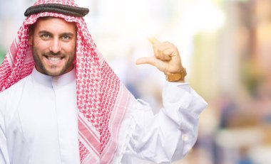 Keffiyeh izole arka plan gülümseyen ve süre seyir ve kamera boyutu işaret parmaklarıyla yapıyor el ile kendinden emin eller üzerinde giyen genç yakışıklı adam. Ölçü kavramı.