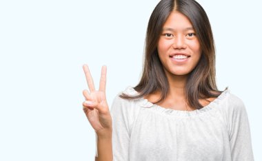Genç Asyalı kadın gösterilen ve parmakları ile işaret izole arka plan üzerinde ikincisi ise kendinden emin ve mutlu gülümseyerek.