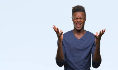 Genç Afro-Amerikan adam kızgın ve silah ile başarı için deli kutluyor izole arka plan üzerinde kaldırdı ve heyecanlı çığlık gözler kapalı. Kazanan kavramı