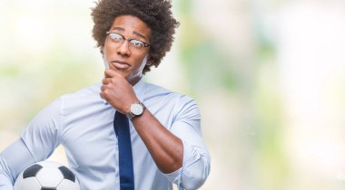 İzole arka plan ciddi bir yüz düşünme hakkında soru, çok karışık bir fikir üzerinde futbol topu tutan Afro Amerikan Yöneticisi adam