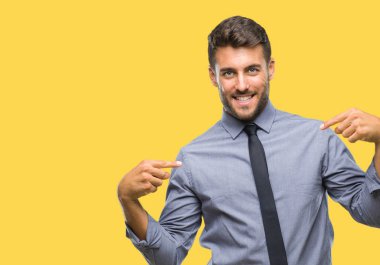 Genç yakışıklı iş adamı yüzünde gülümseme ile kendinden emin görünüyorsun, kendini gururlu ve mutlu parmakları ile işaret izole arka plan üzerinde.