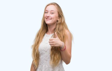 Sarışın genç kadın mutlu ok işareti, başparmak ile parmak, mükemmel işareti yapıyor kocaman bir gülümseme ile